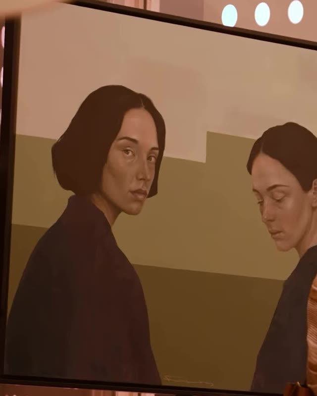 A painting of two dark-haired women against an olive and sand ground, photographed on its stand at the launch evening.
